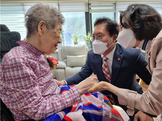 강일출 할머니께 카네이션을 달아드리는 송석준 의원 내외