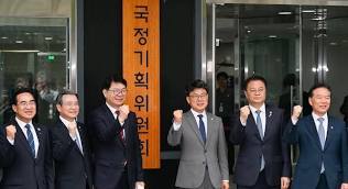 이한주(왼쪽 세 번째) 국정기획위원장과 국정기획위원회 진성준, 김용범, 방기선 부위원장 등 참석자들이 16일 서울 종로구 정부서울청사 창성동 별관에서 현판식을 마치고 관계자들이 힘차게 구호를 외치고있다<br>
<br>
국정기획 위 원회 제공 <br>
